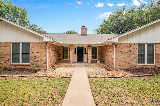 308 Woodway Dr, Victoria, TX 77904 - property entrance featuring brick siding, a chimney, and a lawn