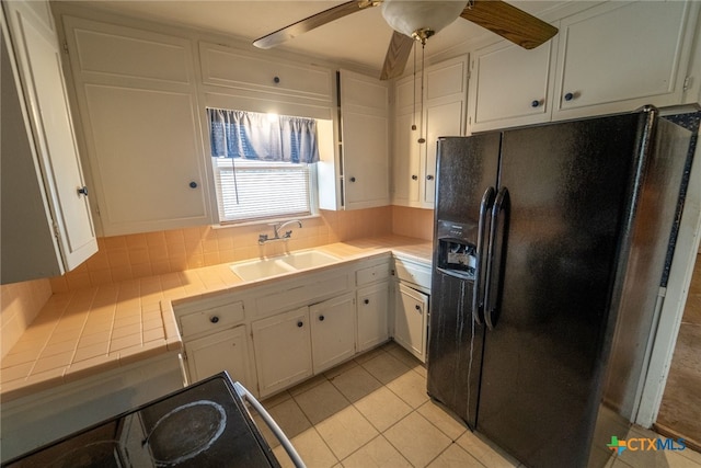 kitchen with sink, white cabinetry, black refrigerator with ice dispenser, range with electric stovetop, and ceiling fan