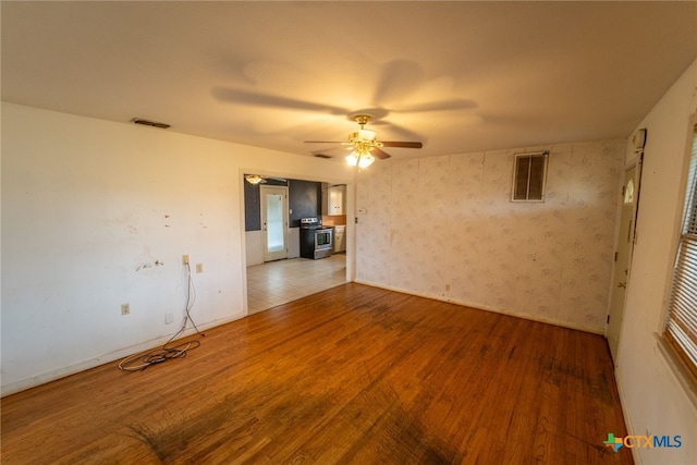 unfurnished living room featuring ceiling fan and hardwood / wood-style floors