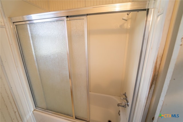 bathroom featuring combined bath / shower with glass door