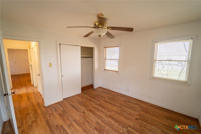 unfurnished bedroom with hardwood / wood-style floors, ceiling fan, and a closet