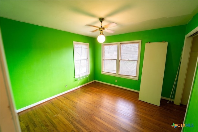 unfurnished bedroom with dark wood-type flooring and ceiling fan