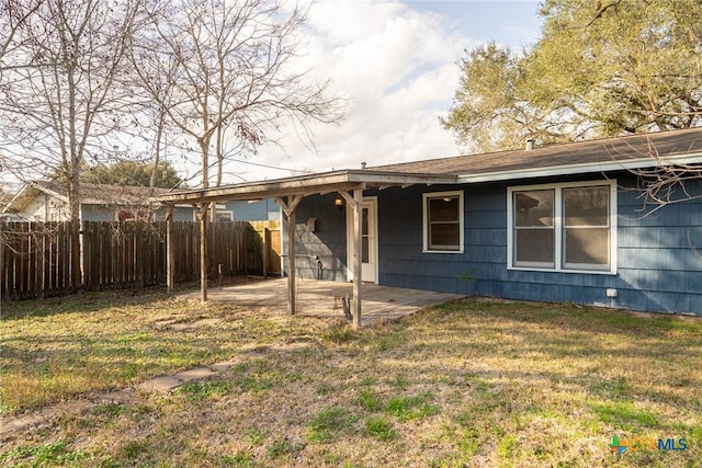 rear view of property featuring a yard and a patio