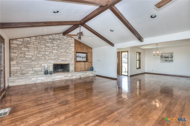 unfurnished living room with hardwood / wood-style floors, ceiling fan with notable chandelier, a stone fireplace, and lofted ceiling with beams