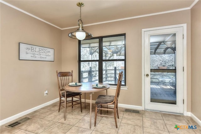 dining room featuring light tile patterned floors and crown molding