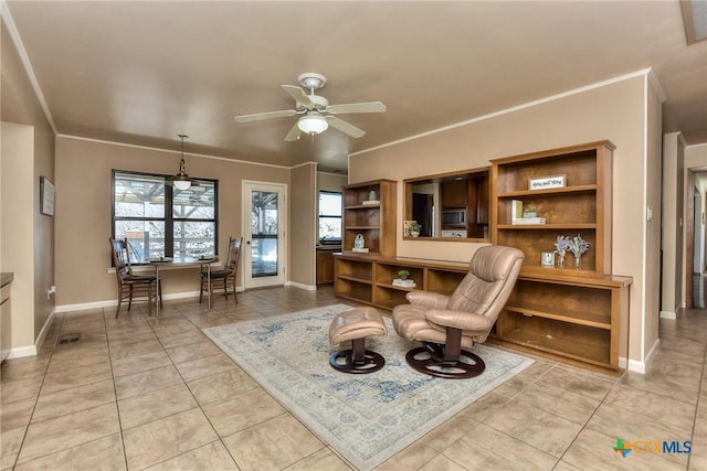 living area with crown molding, ceiling fan, and light tile patterned flooring