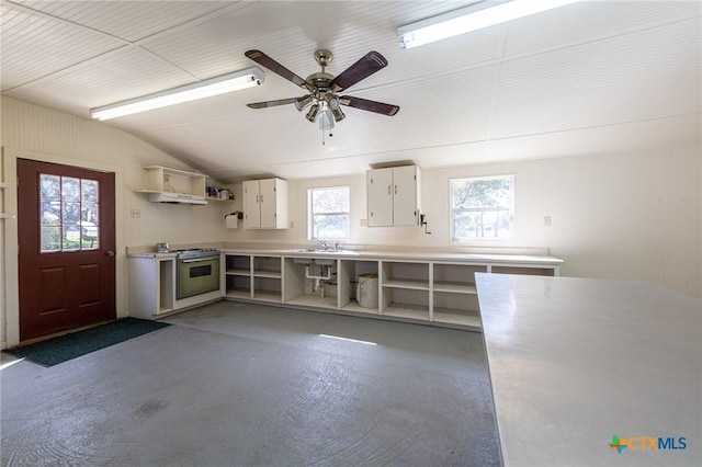 kitchen featuring open shelves, lofted ceiling, light countertops, electric range, and concrete flooring