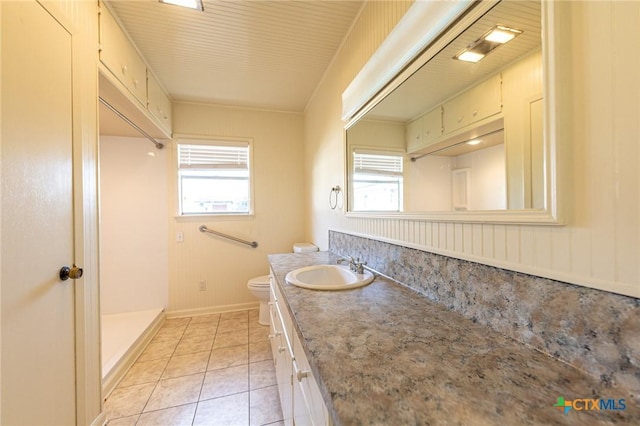 full bath featuring tile patterned floors, toilet, vanity, baseboards, and walk in shower