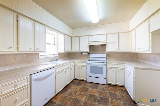 kitchen featuring white appliances, a sink, light countertops, under cabinet range hood, and backsplash