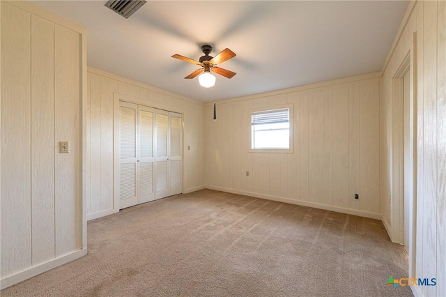 unfurnished bedroom with carpet, visible vents, ceiling fan, and a closet