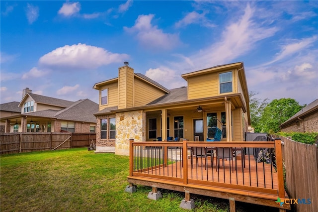 2051 Western Pecan, New Braunfels, TX 78130 - rear view of house featuring a chimney, a fenced backyard, a wooden deck, a ceiling fan, and a lawn