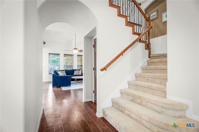 2051 Western Pecan, New Braunfels, TX 78130 - staircase featuring ceiling fan, baseboards, arched walkways, wood finished floors, and a high ceiling