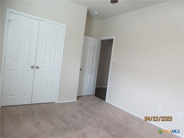 unfurnished bedroom with baseboards, a closet, and carpet