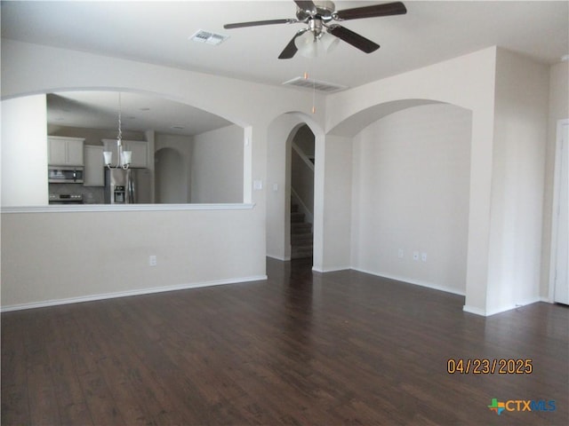 unfurnished living room featuring baseboards, visible vents, ceiling fan, and dark wood-type flooring
