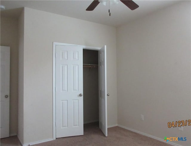 unfurnished bedroom featuring baseboards, a ceiling fan, a closet, and carpet