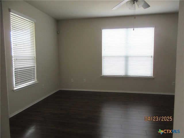 spare room with ceiling fan, baseboards, and dark wood finished floors