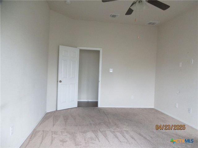 carpeted empty room with baseboards, visible vents, and ceiling fan