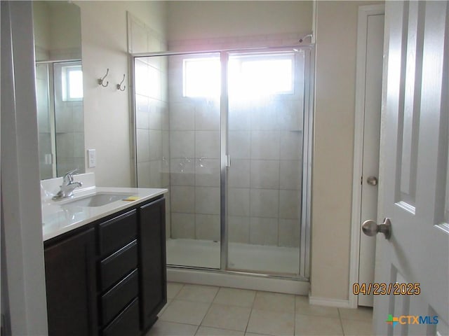 bathroom with a stall shower, vanity, and tile patterned flooring