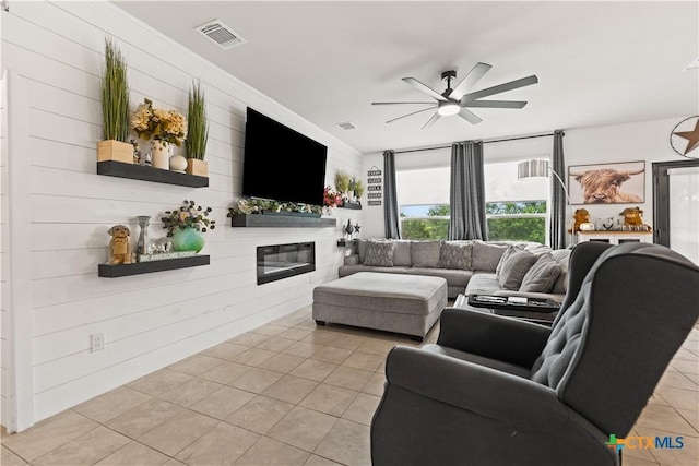 5998 Galveston Rd, Belton, TX 76513 - living area featuring ceiling fan, a glass covered fireplace, and light tile patterned floors
