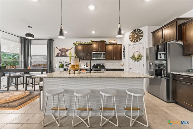 5998 Galveston Rd, Belton, TX 76513 - kitchen with appliances with stainless steel finishes, dark brown cabinetry, a sink, light stone countertops, and a breakfast bar