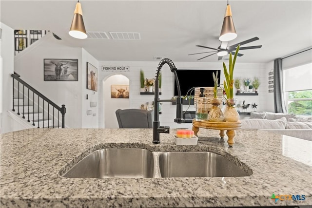 5998 Galveston Rd, Belton, TX 76513 - kitchen with open floor plan, a sink, ceiling fan, light stone countertops, and hanging light fixtures