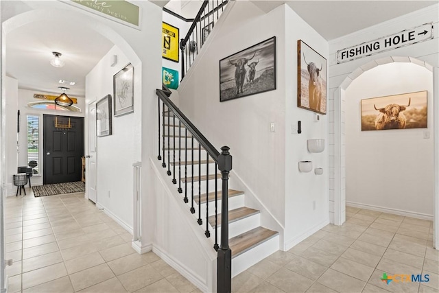 5998 Galveston Rd, Belton, TX 76513 - entrance foyer with light tile patterned floors, stairway, arched walkways, and baseboards