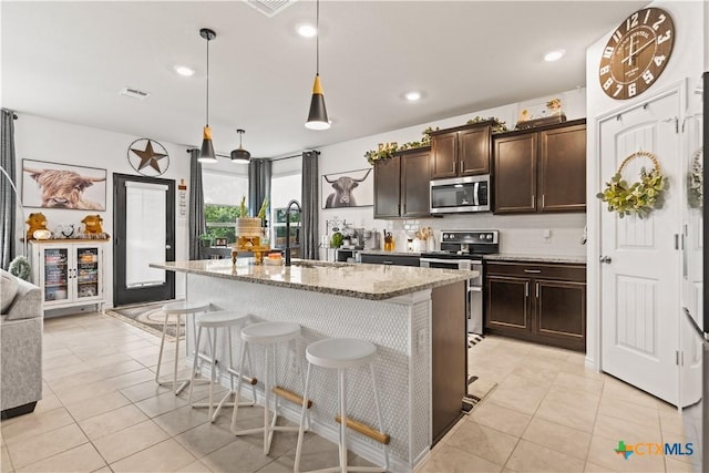 5998 Galveston Rd, Belton, TX 76513 - kitchen featuring appliances with stainless steel finishes, a sink, light stone countertops, light tile patterned floors, and recessed lighting