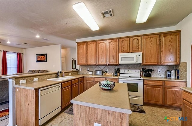 1505 Line Dance Ct, Killeen, TX 76542 - kitchen featuring white appliances, a sink, a peninsula, light countertops, and a textured ceiling
