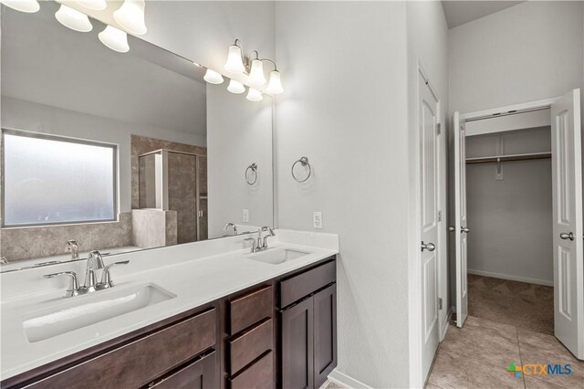 8113 Iron Gate Dr, Temple, TX 76502 - bathroom featuring double vanity, a shower stall, a walk in closet, and tile patterned floors