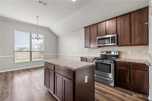 8113 Iron Gate Dr, Temple, TX 76502 - kitchen featuring appliances with stainless steel finishes, a center island, vaulted ceiling, dark wood finished floors, and decorative backsplash