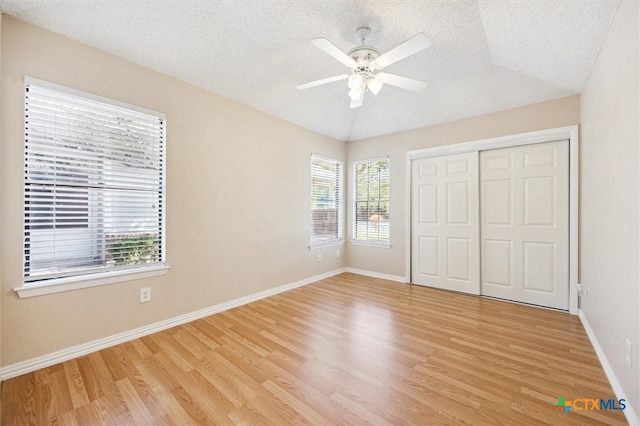 unfurnished bedroom with light hardwood / wood-style flooring, multiple windows, and ceiling fan