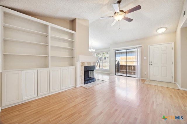 unfurnished living room featuring light wood-type flooring, a textured ceiling, and a fireplace