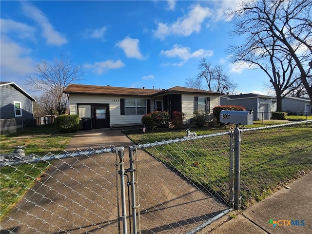 ranch-style home with a fenced front yard, a front yard, and a gate