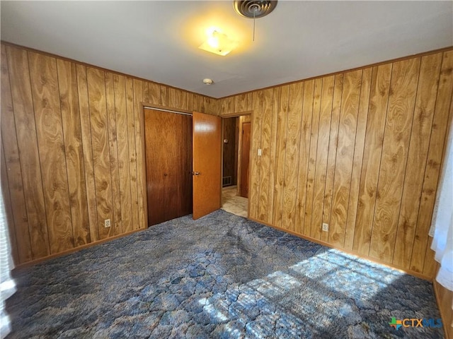 carpeted empty room with wooden walls