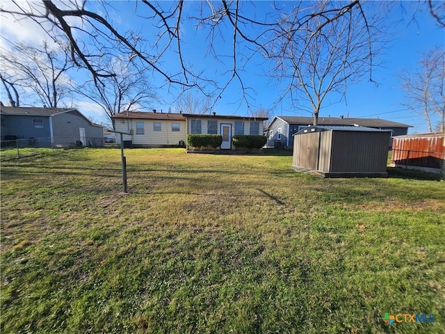 view of yard featuring a storage shed, an outdoor structure, and fence