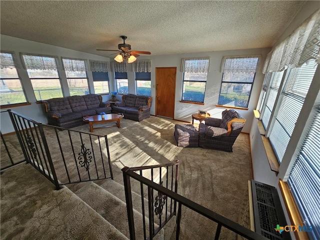 living room featuring a wealth of natural light, carpet, ceiling fan, and a textured ceiling