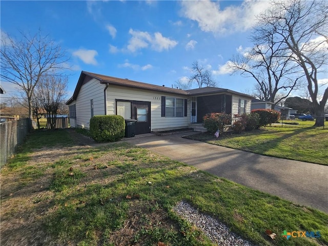 view of front of home featuring a front lawn, fence, and driveway