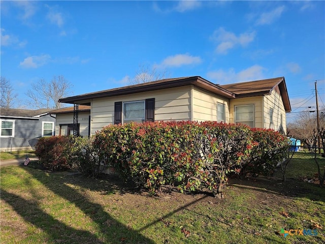 view of property exterior with fence and a lawn