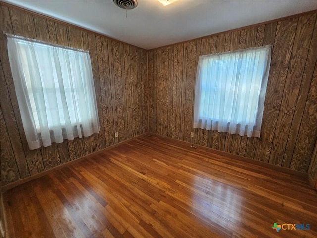 unfurnished room featuring visible vents and hardwood / wood-style flooring