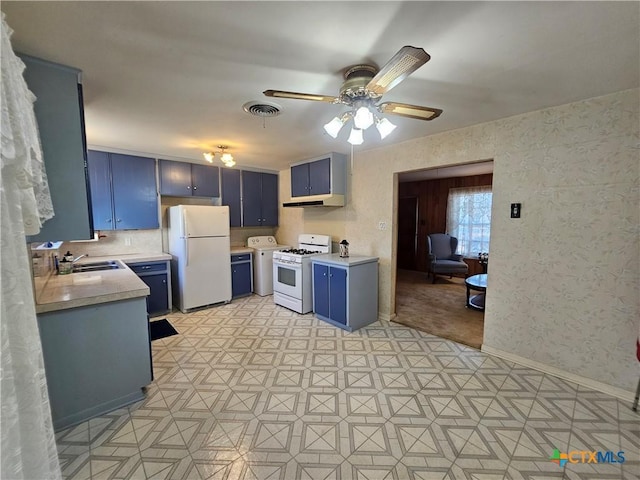 kitchen featuring visible vents, light countertops, white appliances, blue cabinets, and a sink