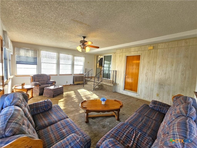 living room with carpet floors, a textured ceiling, and ceiling fan