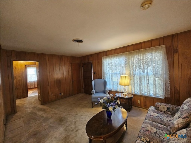 interior space with visible vents, carpet, and wood walls