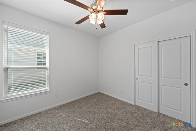 unfurnished bedroom featuring ceiling fan, carpet flooring, and a closet