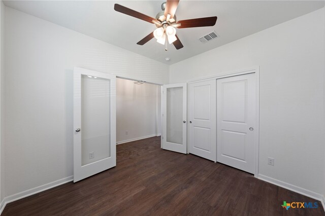 unfurnished bedroom featuring dark wood-type flooring, a closet, lofted ceiling, and ceiling fan