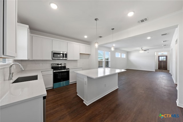 kitchen with stainless steel appliances, dark hardwood / wood-style flooring, a center island, white cabinets, and sink