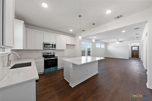 606 Killam Dr, Temple, TX 76502 - kitchen featuring appliances with stainless steel finishes, a sink, tasteful backsplash, light countertops, and ornamental molding