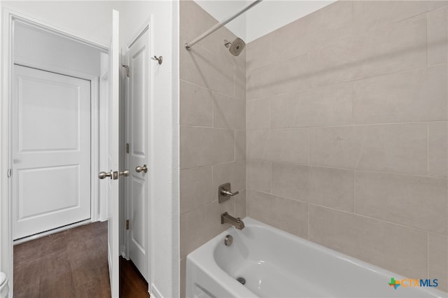 bathroom with tiled shower / bath combo and hardwood / wood-style flooring