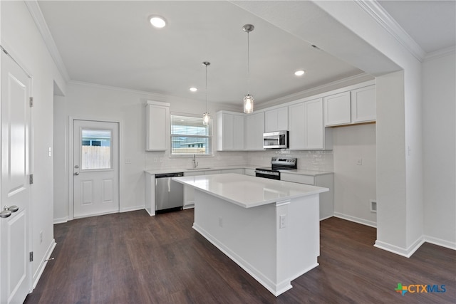 kitchen featuring sink, appliances with stainless steel finishes, dark hardwood / wood-style floors, a center island, and white cabinets