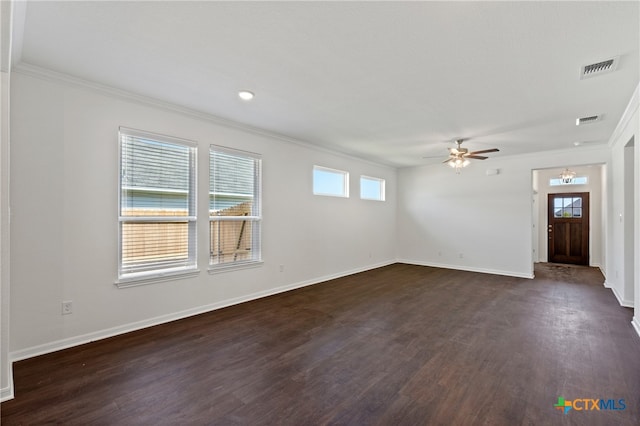 spare room with ornamental molding, a wealth of natural light, dark wood-type flooring, and ceiling fan