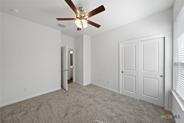 unfurnished bedroom featuring ceiling fan, light carpet, and a closet